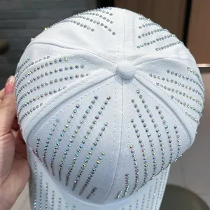 Close-up of a white baseball cap featuring vibrant, multi-colored rhinestones in a sunburst pattern