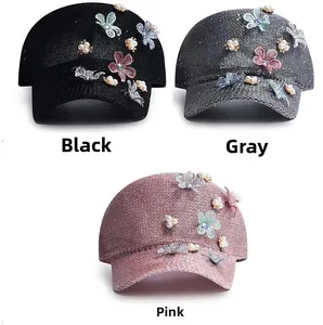 Detailed view of knitted baseball caps featuring pearl flowers and sequin butterflies