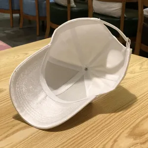 Close-up of white baseball cap with adjustable metal buckle and breathable interior lining