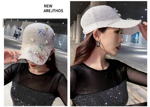 Detail of white knitted mesh baseball cap featuring colorful 3D flowers and pearl accents