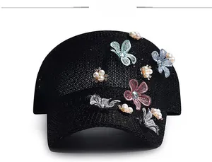 Detail of 3D embroidered butterflies and pearl clusters on black mesh baseball cap