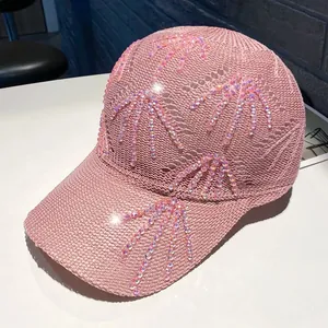 Dettaglio del cappello da baseball in maglia rosa con trama traforata e strass luminosi