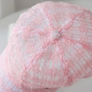 Detailed close-up of pink lace hollow-out pattern and breathable fabric on baseball cap
