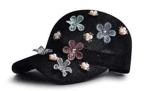 Detail of black knit baseball cap with 3D fabric flowers, pearls and crystal accents