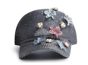 Detailed view of knitted baseball cap featuring 3D lace flowers and pearl embellishments