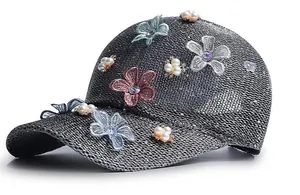 Detail of silver knitted cap with sequins, lace flowers and faux pearls embellishment