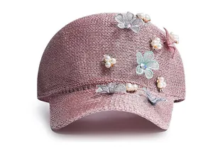 Detail of light pink knitted baseball cap with lace flowers and faux pearl embellishments