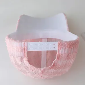 Detailed back view of pink lace baseball cap with white adjustable strap and buckle