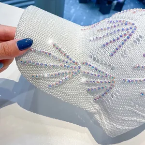 Dettaglio ravvicinato di cappello bianco in maglia con strass scintillanti e trama a rete