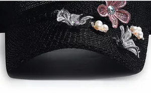 Macro view of mesh baseball cap with 3D butterfly embroidery and pearl accents