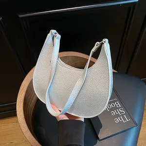 Minimalistische silberne Halbmondtasche aus Leder mit feiner Narbung und Griff