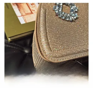 Détail de la couture et de la texture pailletée sur un sac de soirée doré chic