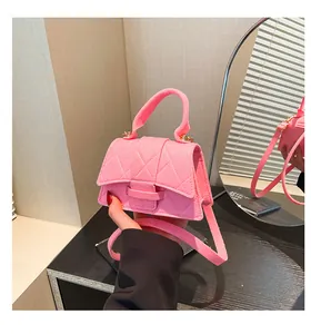 Close-up of pink quilted mini bag with stylish clasp and elegant top handle texture