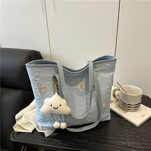 Borsa tote trapuntata azzurra con ricamo a farfalla e ciondolo a forma di nuvola