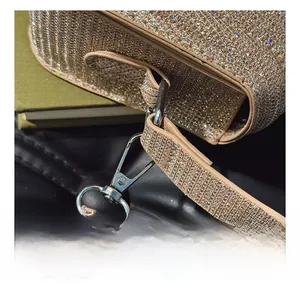 Gros plan sur le sac de soirée doré à strass avec crochet métallique argenté poli brillant
