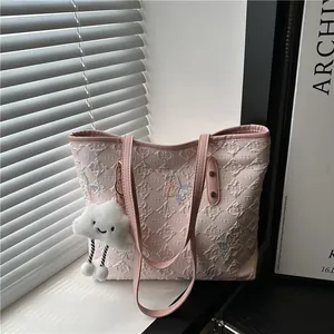 Borsa tote rosa con farfalla ricamata e ciondolo a nuvola su davanzale soleggiato