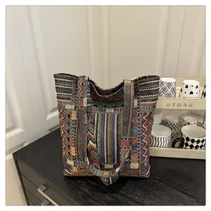 Détail d'un sac cabas ethnique coloré avec motifs géométriques bohèmes sur surface en bois