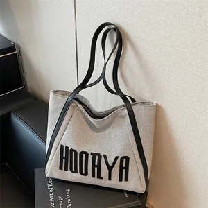 Large beige canvas tote bag with black leather straps and HOORYA print for daily commute
