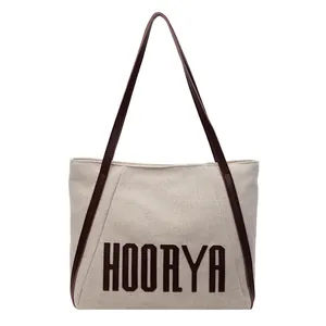 Minimalist canvas tote bag with brown leather handles and HOORYA print design