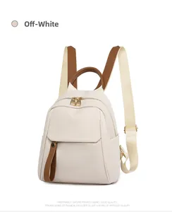 Close-up of cream Oxford fabric mini backpack with brown leather accents and gold zipper
