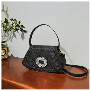 Détail d'un sac à main noir pailleté élégant avec boucle en cristal sur table en bois