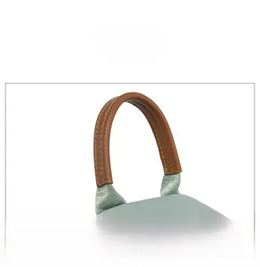Close-up of brown faux leather handle with stitching on teal oxford fabric backpack
