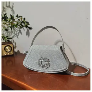 Gros plan du sac à paillettes argentées avec boucle de strass de luxe sur bureau en bois