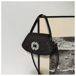 Détail d'un sac à main noir pailleté avec boucle luxueuse en strass argentés