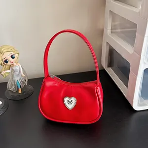 Chic red heart-shaped crescent handbag with a single handle and sparkling bow detail