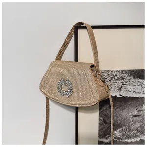 Détail d'un sac doré scintillant avec une boucle luxueuse en strass carrés
