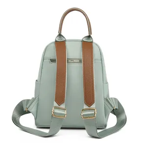 Mint green high-density oxford backpack with brown leather straps and gold hardware zippers