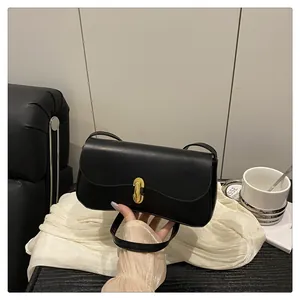 Detail view of stylish black leather underarm bag with unique wave edge and gold metal lock