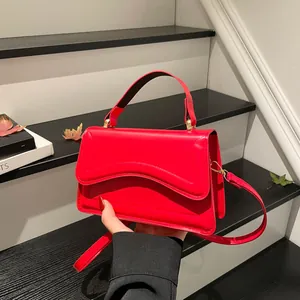 French style vibrant red crossbody bag with top handle on minimalist stairs