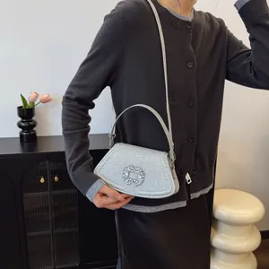 Sac bandoulière argenté scintillant avec boucle fleurie en strass et poignée élégante