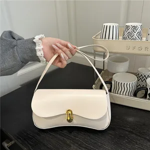 Retro cream beige underarm shoulder bag with golden buckle shown in indoor setting