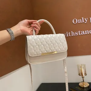 Elegante borsa a tracolla trapuntata beige con dettagli dorati e manico superiore