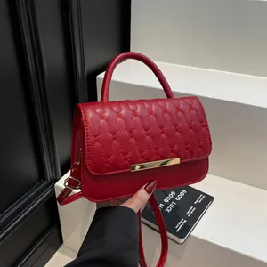 Elegante borsa a tracolla trapuntata rossa con dettagli dorati e ricami a onde