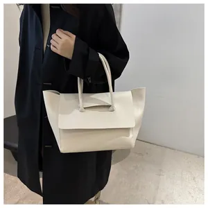 Detail of off-white oversized tote bag with flap closure and soft matte leather texture