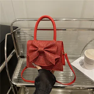 Sac de soirée rouge à paillettes avec grand nœud et poignée pour occasions élégantes