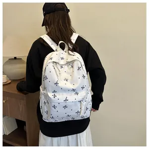 Détail d'un sac à dos blanc à nœuds marins avec poche latérale et étiquette mode