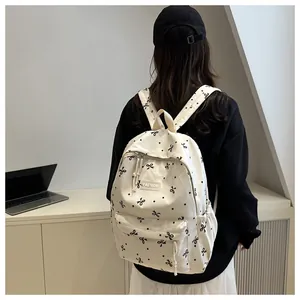 Vue arrière d'un sac à dos en toile beige avec motifs de nœuds noirs en scène de vie