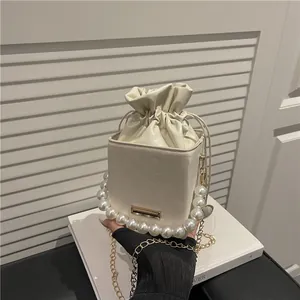 Elegante borsa a secchiello bianca crema con manico di perle e tracolla a catena d'oro
