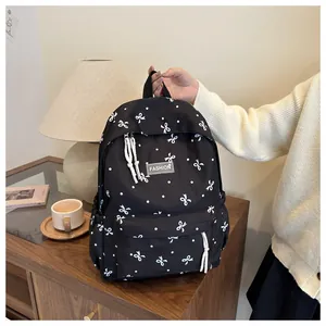 Détail d'un sac à dos noir avec nœuds blancs et étiquette Fashion dans un décor maison