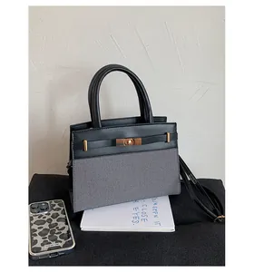 Chic black leather and grey fabric patchwork handbag with golden turn-lock closure