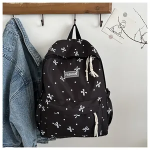 Gros plan détaillé du sac à dos noir avec motifs nœuds blancs et étiquette de mode