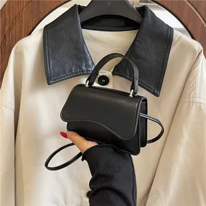Sac bandoulière noir chic avec rabat ondulé asymétrique et finition cuir lisse brillant