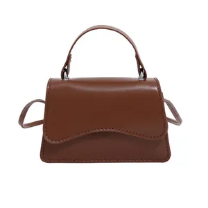 Petit sac à main marron avec rabat vague et bandoulière réglable pour porté épaule ou croisé