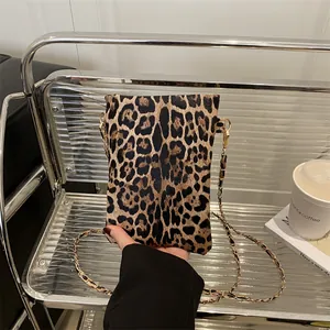 Mini borsa a tracolla leopardata con catena dorata mostrata in un contesto di moda