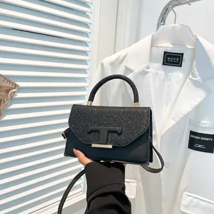 Chic black vintage crossbody bag with glitter panel and golden T logo hardware