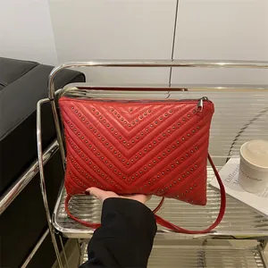 Red V-quilted envelope shoulder bag with silver studs and slim leather strap